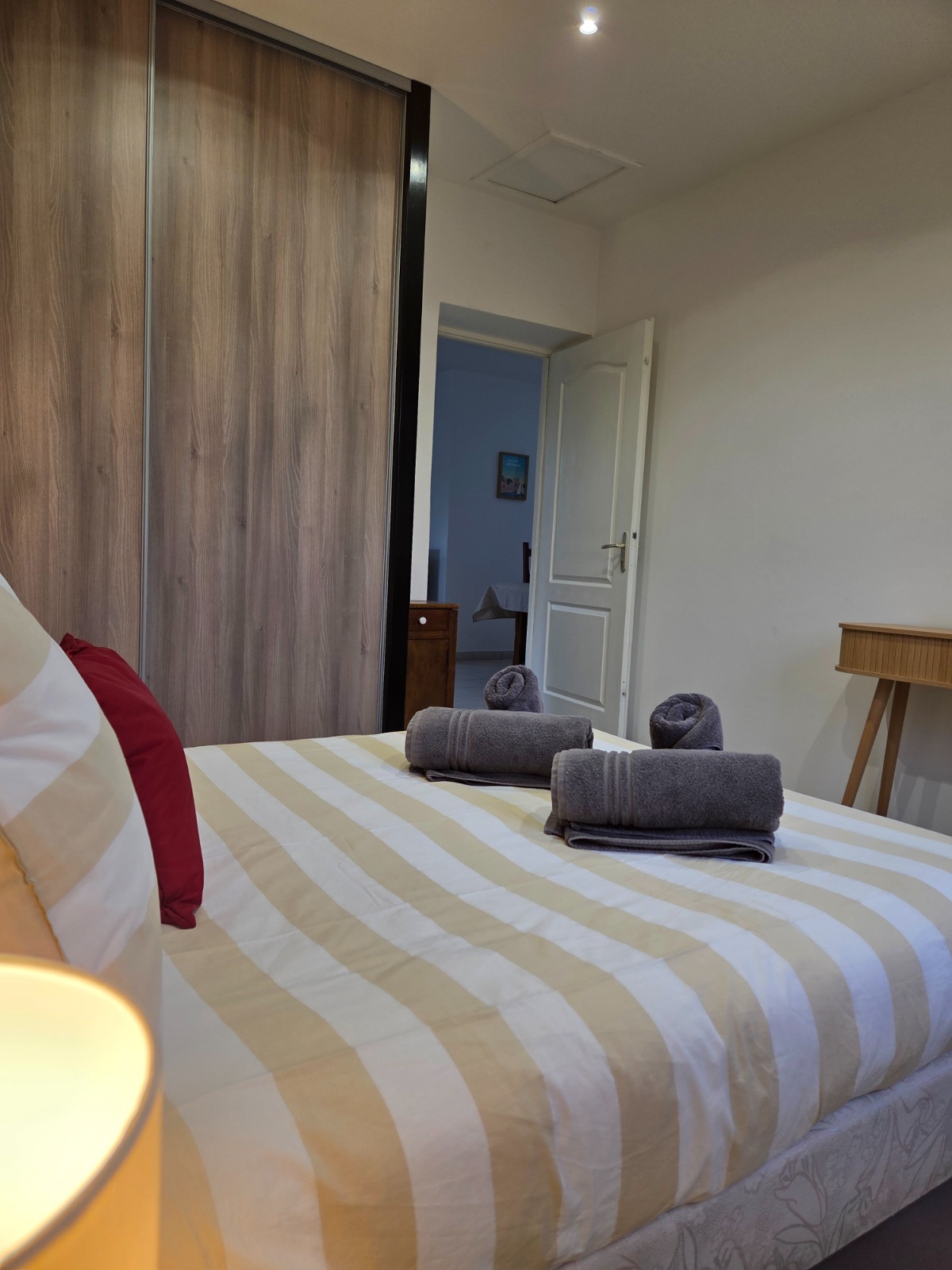 Chambre avec lit rayé et serviettes pliées — hébergement Airbnb soigné dans le Vaucluse